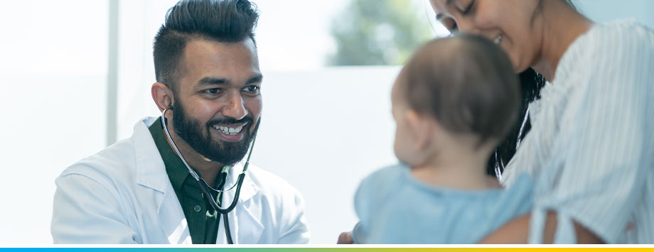 Male doctor meets with infant patient and mother